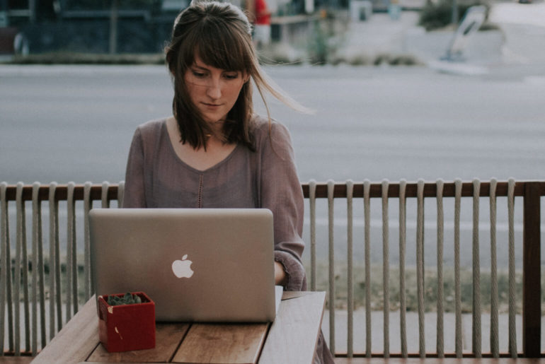 A woman working remotely from a table with potential pitfalls.
