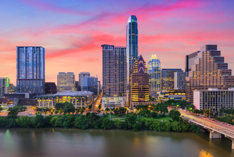 a city skyline with a bridge over a river.