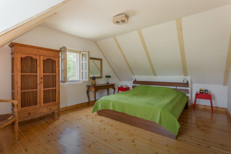 a bedroom with a bed and a green blanket.