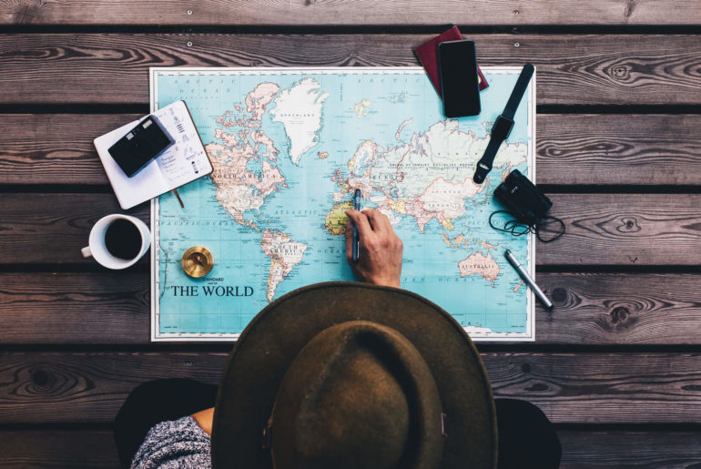 a person sitting at a table looking at a map.