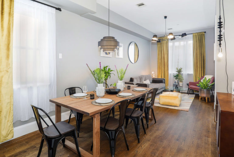 A dining room with a wooden Aleph table surrounded by chairs.