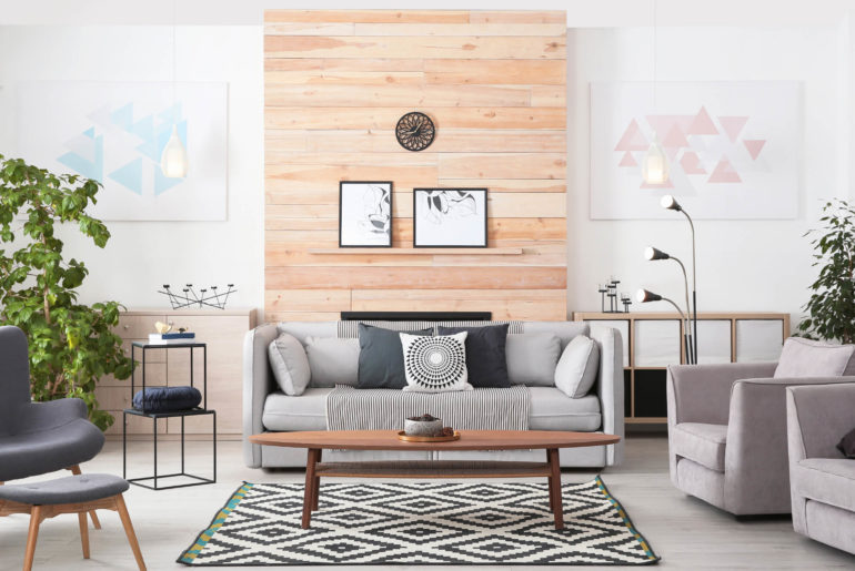 a living room filled with furniture and a wooden wall.