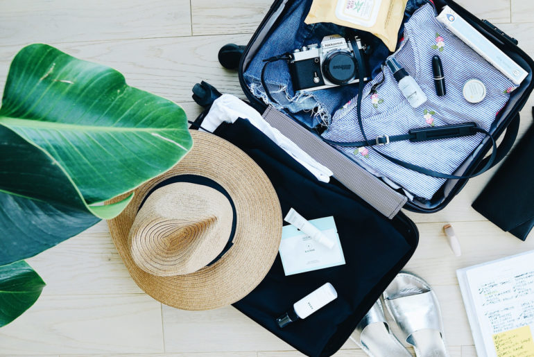 an open suitcase with a hat and other items.