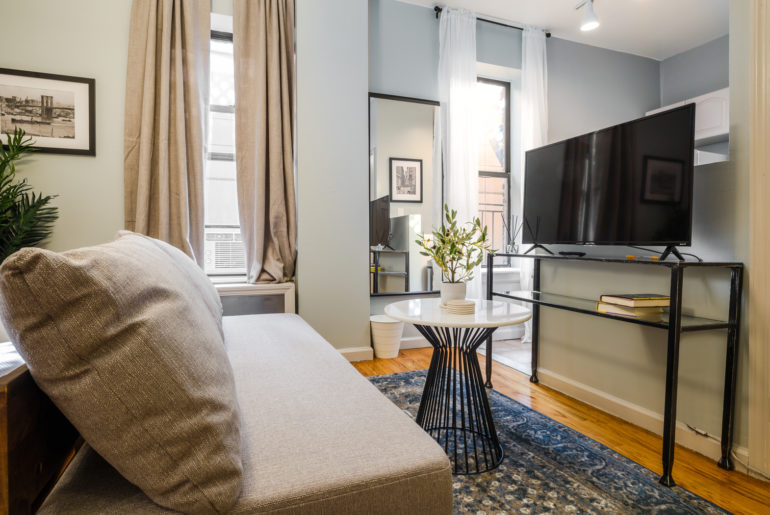 a living room with a couch a table and a tv.