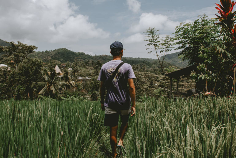 man walking through rice patties in Bali