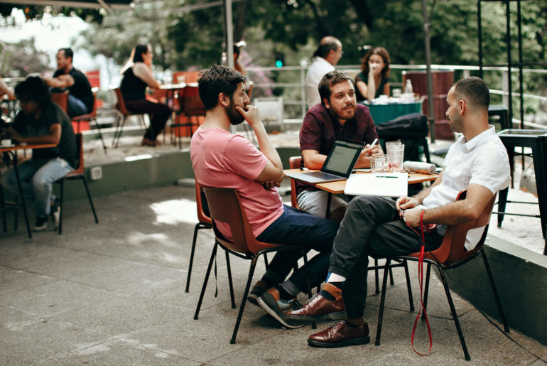 A group of people working on laptops together to improve their time management skills.