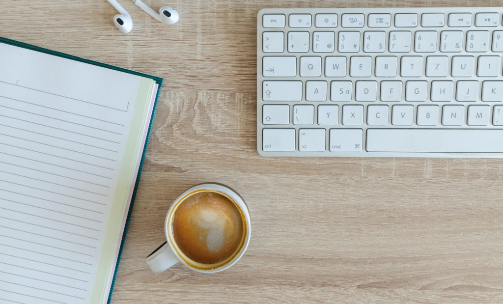 coffee, notebook, and external keyboard