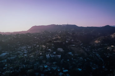 an aerial view of a city with mountains in the background.