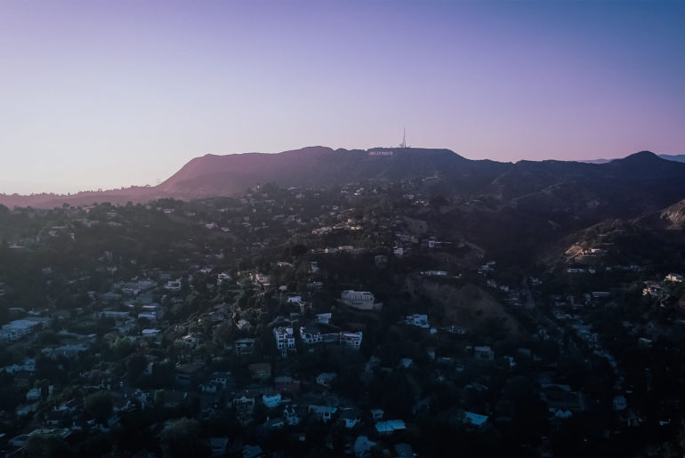 an aerial view of a city with mountains in the background.