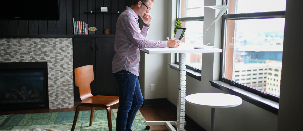 man working from a standing desk