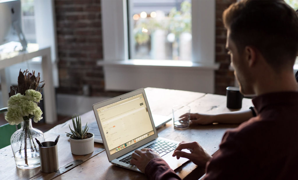 man working remotely from cafe