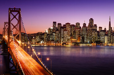 a city skyline with a bridge in the foreground.