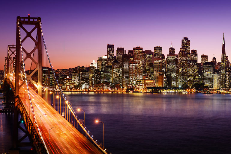 a city skyline with a bridge in the foreground.