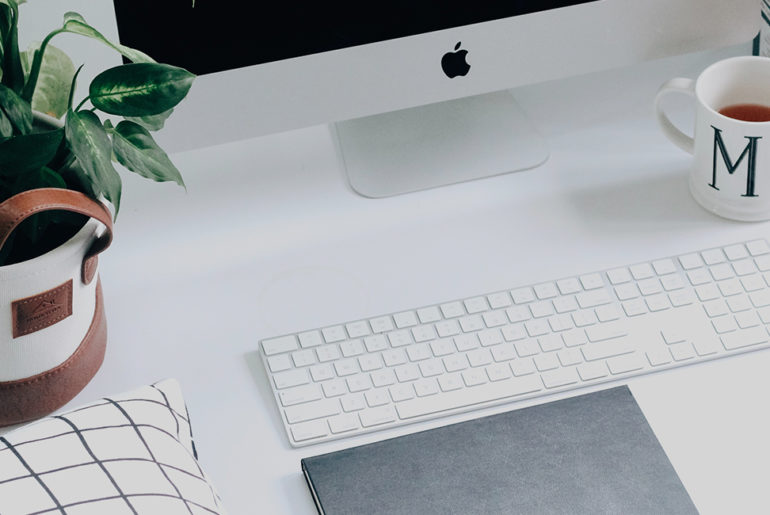 A morning routine that includes a desk with a computer, keyboard, mouse and a potted plant.