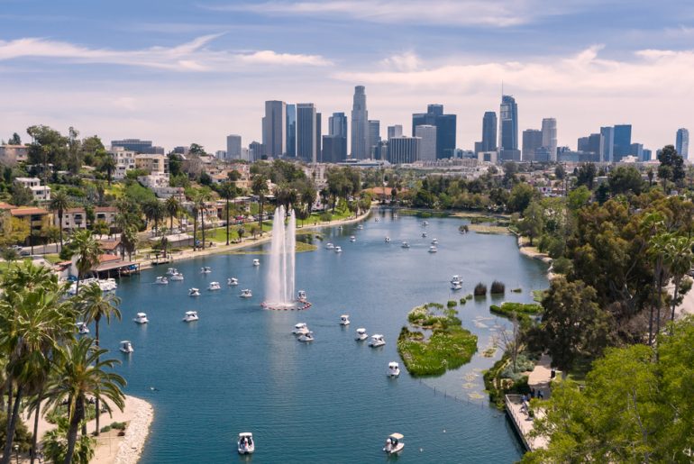 a view of a lake with boats in it and a city in the background.