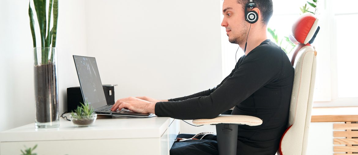 A man working remotely with a laptop and headphones, promoting wellness.