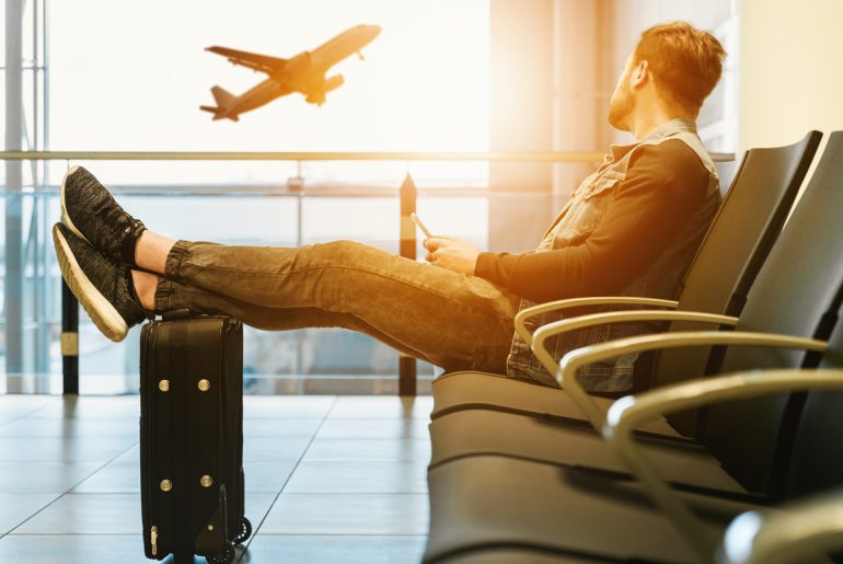 a man sitting on a chair in an airport.