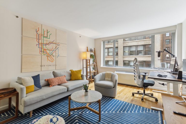 An apartment living room with furniture and a large window.